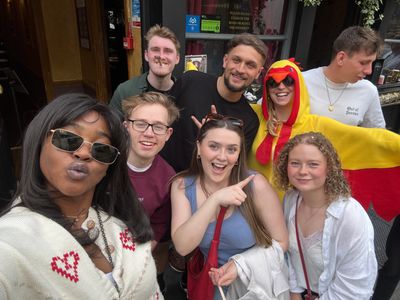 teammates performing a playful photo prompt in a busy bar