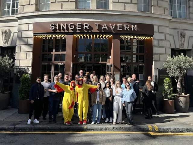 A work team outside the Singer Tavern in London with two Chickens