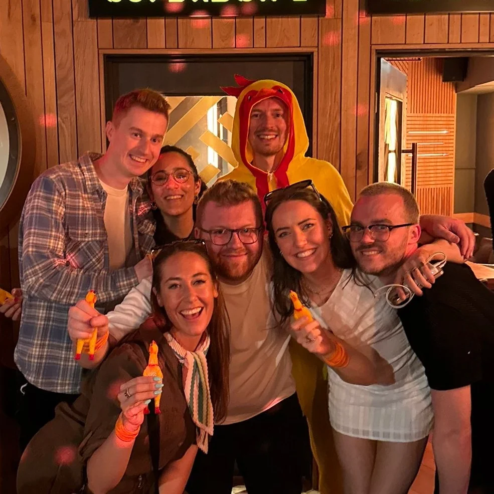 A team of singles posing with rubber chickens